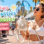 Woman holding a cooling fan water bottle while walking through a sunny theme park
